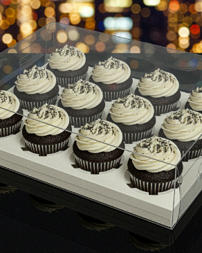 Clear plastic container with cupcakes on a blurred bokeh background