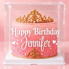 Personalized clear cake box featuring a pink and gold crown birthday cake with white “Happy Birthday Jennifer” lettering.